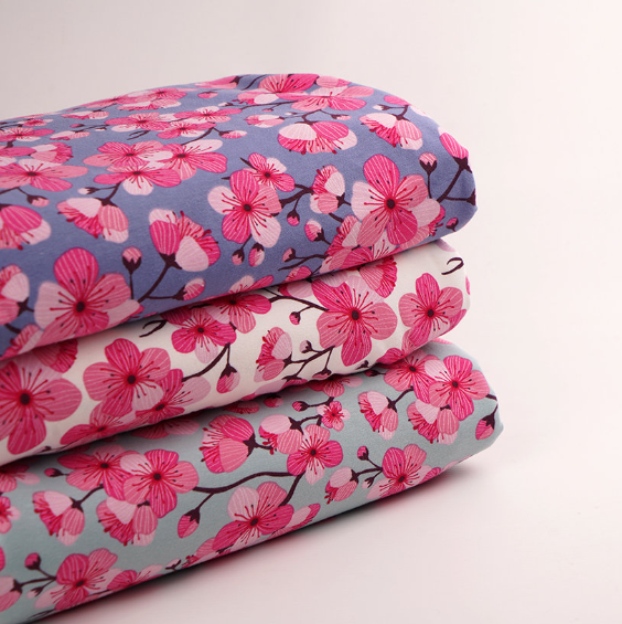 organic jersey fabric with pink cherry blossom print on different backgrounds